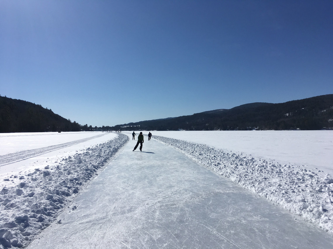 People Iceskating on path on lake